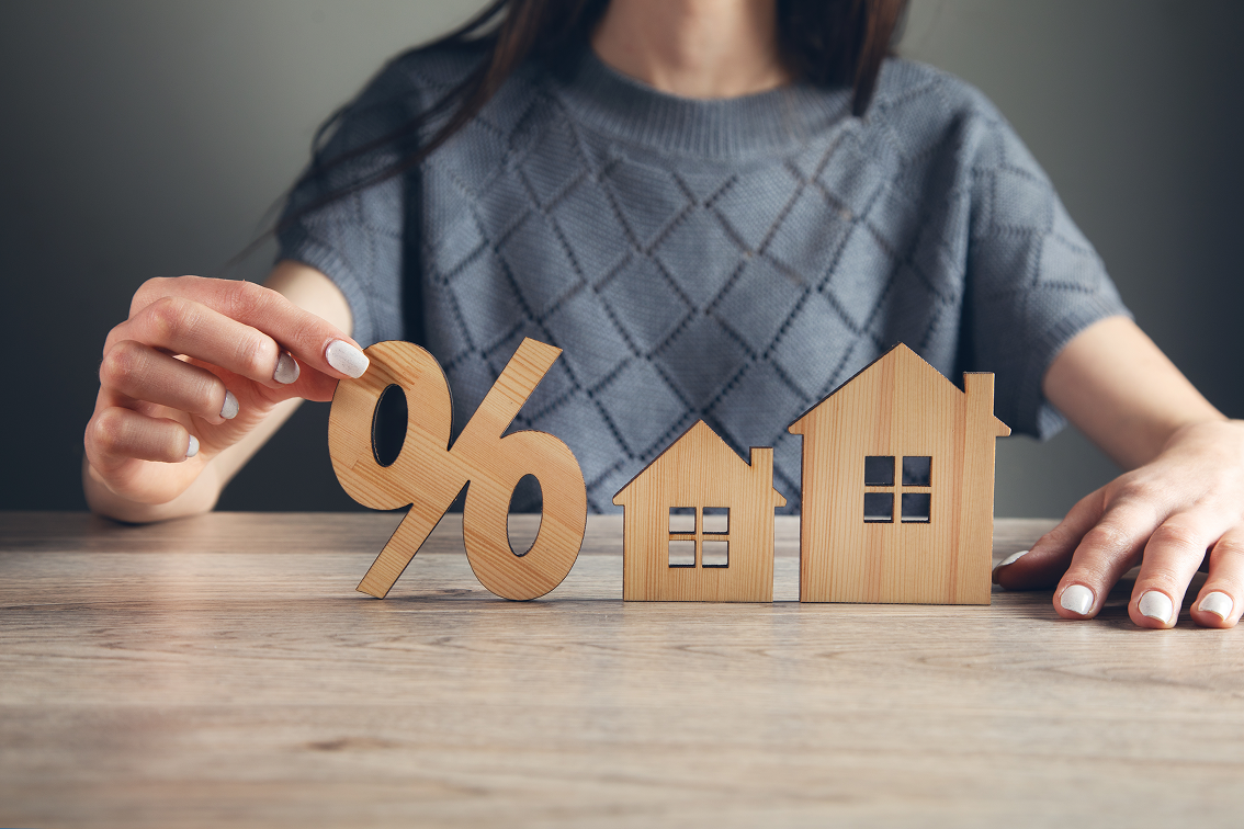 Famille primo-accédant heureuse devant leur maison individuelle neuve financée par PTZ 2026